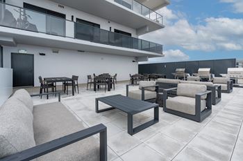 A patio with a table and chairs is in front of a white building